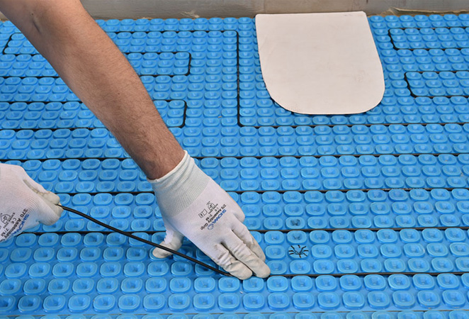 Installing floor heating cable in the Prodeso membrane.