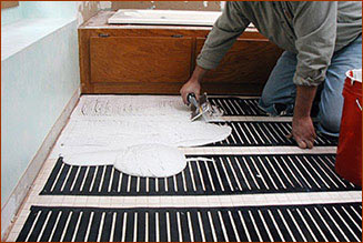Applying thinset over the polyethylene FloorHeat floor heating element.